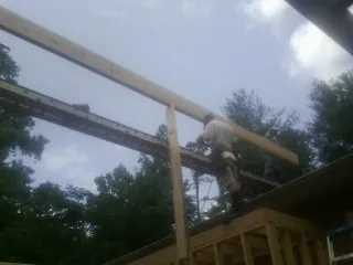 Carpenter setting a ridge beam over a new addition frame — Ice Dam Removal by Roofing Brothers in Mentone